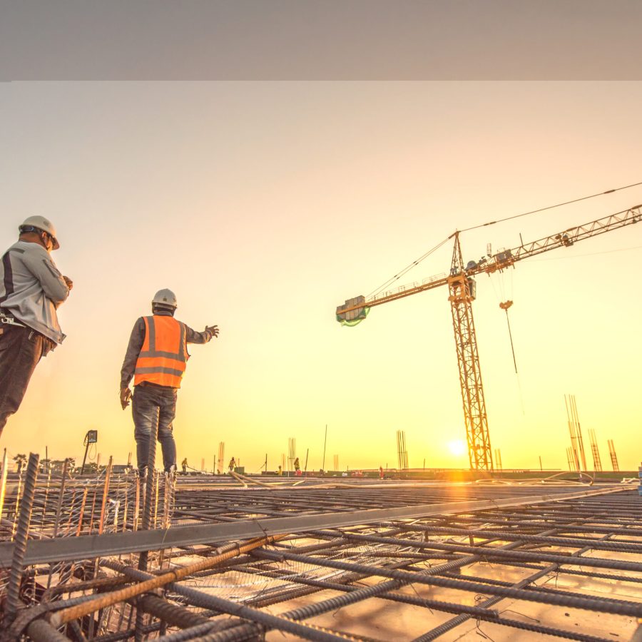 silhouette group of worker and civil engineer in safety uniform install reinforced steel column in construction site during sunset time industrial concept